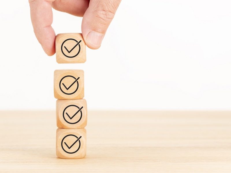 Checking or checklist concept. Hand picked wooden cube block with check icon. Copy space