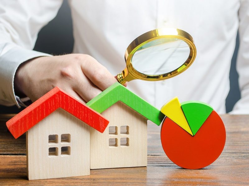 Man is studying the structure of housing costs with a magnifying glass. Revision of utility bills and tariffs. Efficient water energy consumption. Applying modern effective materials in real estate.
