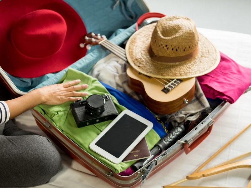 Woman hand packing a luggage for a new journey and travel for a